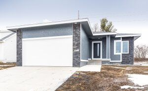 A grey house with metal and stone exterior, built by Kruse Development.