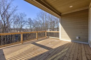 A picture of a wooden balcony looking into the backyard, attached to a home built by Kruse Development.